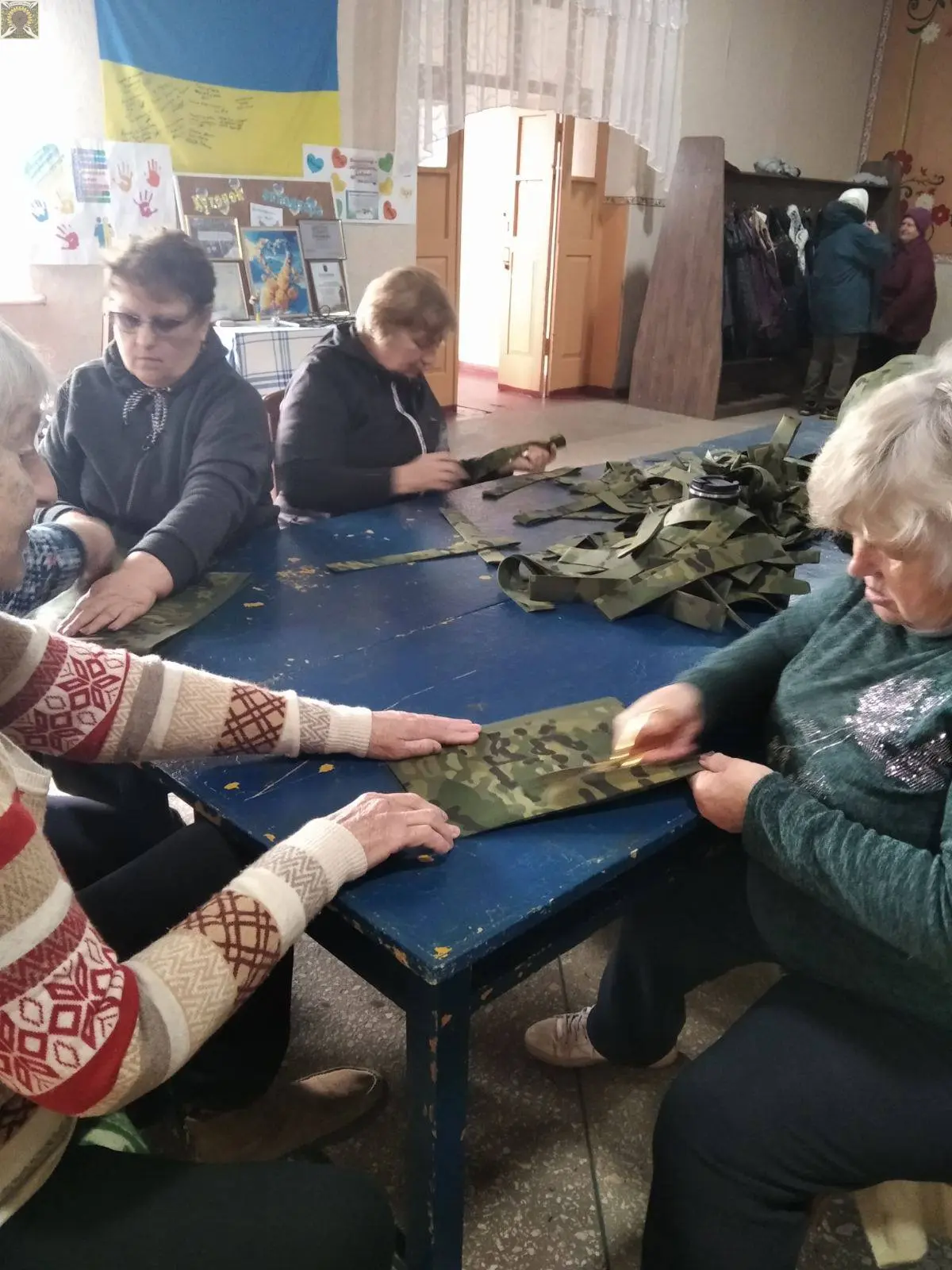 Волонтерка зосереджена на плетінні оберега