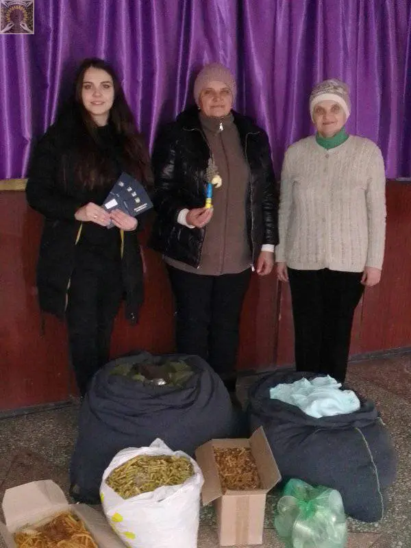 Волонтери Микільського на фоні своїх виробів