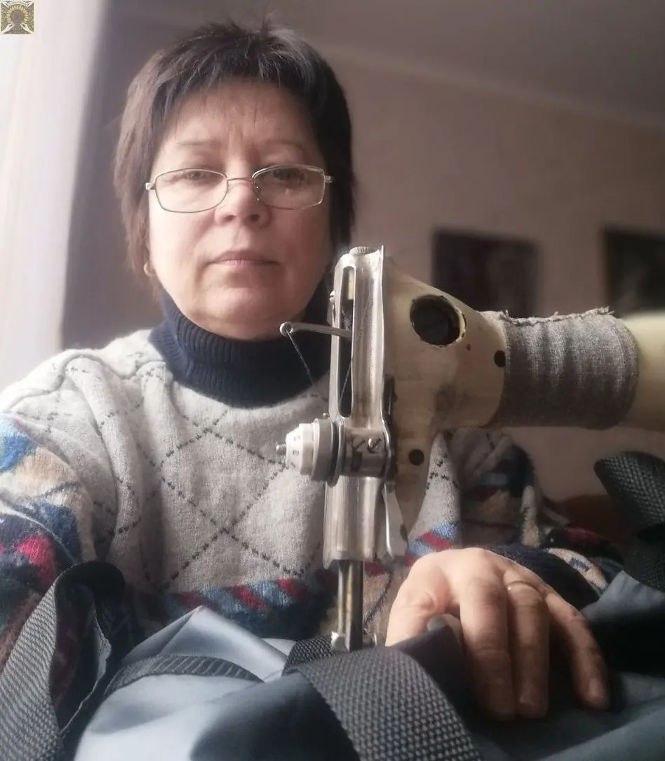 Волонтерка зшиває деталі нош на швейній машинці